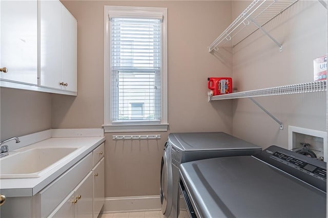 washroom with a sink, cabinet space, and washing machine and clothes dryer