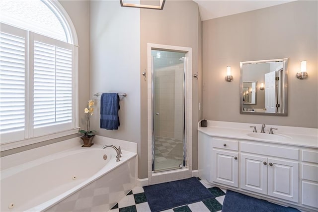 full bathroom featuring vanity, a bath, and a stall shower