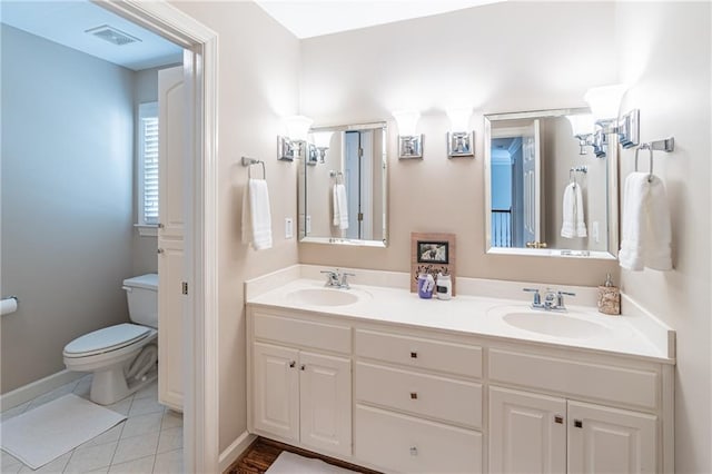 full bath featuring tile patterned floors, toilet, double vanity, and a sink