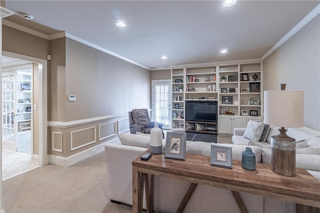 living room with light carpet, ornamental molding, recessed lighting, wainscoting, and a decorative wall