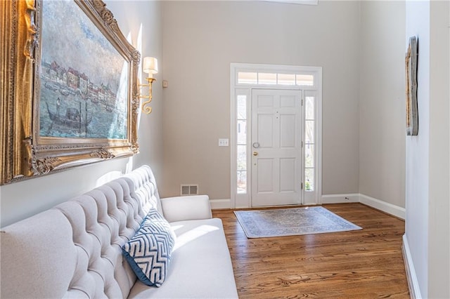 entrance foyer with baseboards and wood finished floors