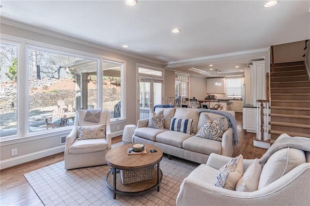 living room with crown molding, stairway, and a wealth of natural light