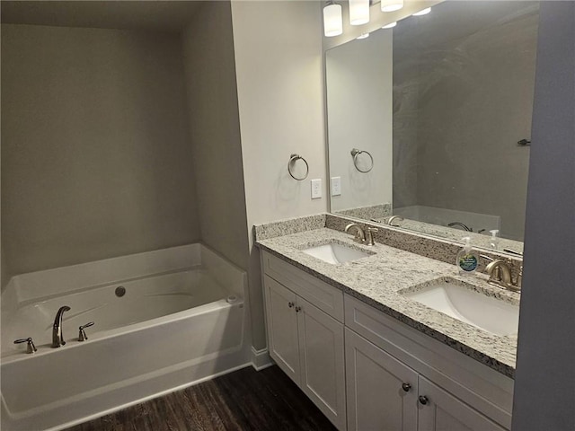 bathroom featuring vanity, hardwood / wood-style flooring, and a bathing tub