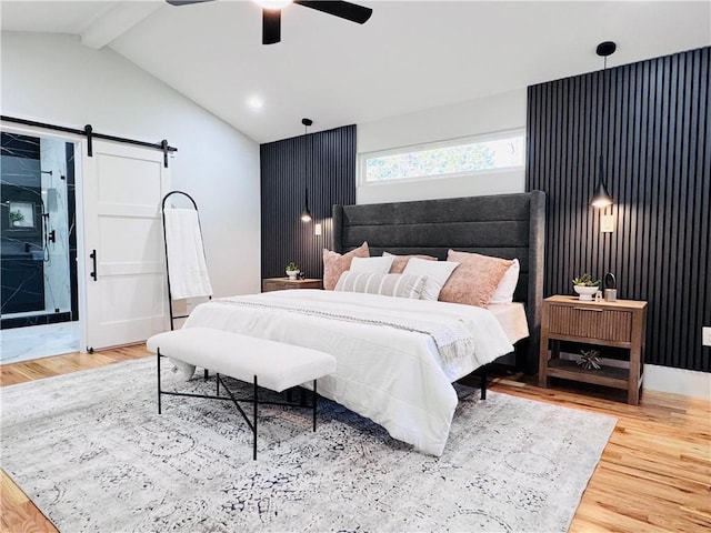 bedroom featuring ceiling fan, hardwood / wood-style flooring, and a barn door