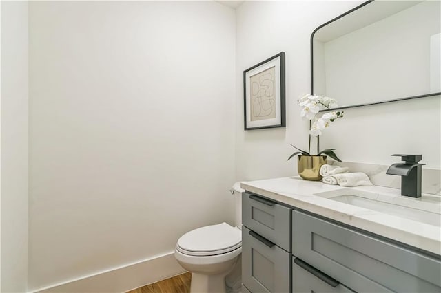 bathroom featuring hardwood / wood-style floors, toilet, and vanity