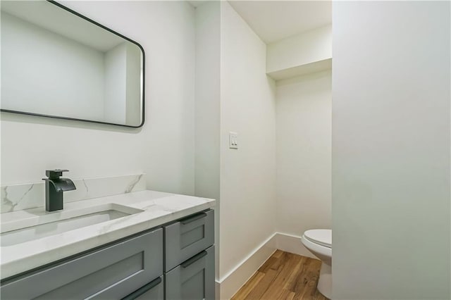 bathroom with hardwood / wood-style floors, toilet, and vanity