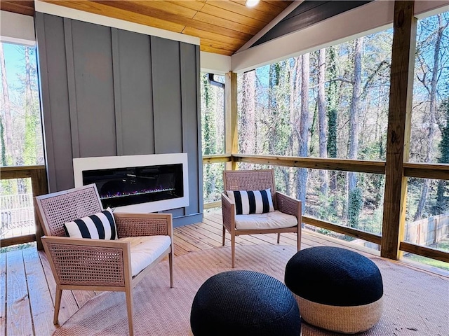 sunroom featuring a fireplace, vaulted ceiling, and wood ceiling