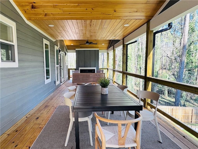 sunroom / solarium with ceiling fan, wood ceiling, and a healthy amount of sunlight