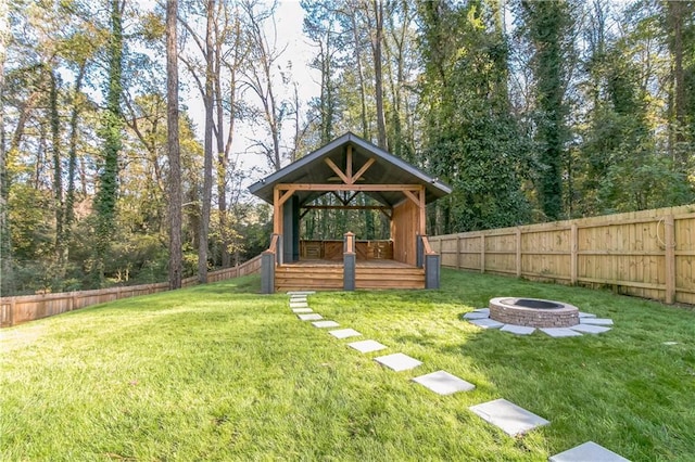 view of yard featuring an outdoor fire pit, a gazebo, and a deck