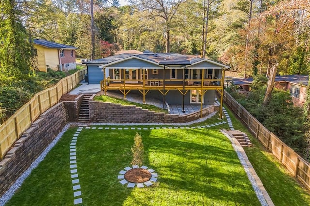 rear view of house featuring a patio, a deck, and a lawn