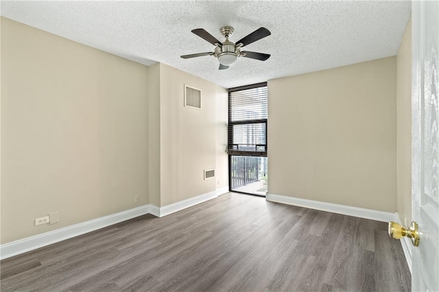 620 Peachtree St NE Unit 911, Atlanta, GA 30308 - empty room with a textured ceiling, dark wood-style floors, a ceiling fan, and a wall of windows