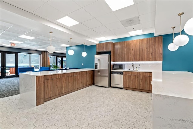 620 Peachtree St NE Unit 911, Atlanta, GA 30308 - kitchen with stainless steel appliances, a peninsula, brown cabinets, a paneled ceiling, and open floor plan