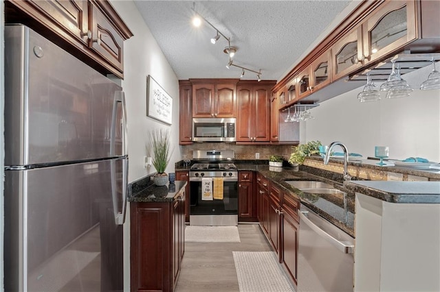 620 Peachtree St NE Unit 911, Atlanta, GA 30308 - kitchen with appliances with stainless steel finishes, dark stone counters, light wood-style floors, a textured ceiling, and backsplash