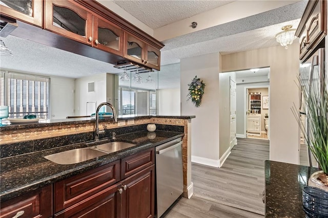 620 Peachtree St NE Unit 911, Atlanta, GA 30308 - kitchen with dishwasher, a textured ceiling, light wood finished floors, dark stone counters, and glass insert cabinets