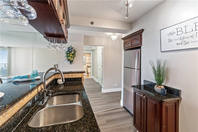 620 Peachtree St NE Unit 911, Atlanta, GA 30308 - kitchen featuring freestanding refrigerator, a textured ceiling, light wood-type flooring, and dark stone counters