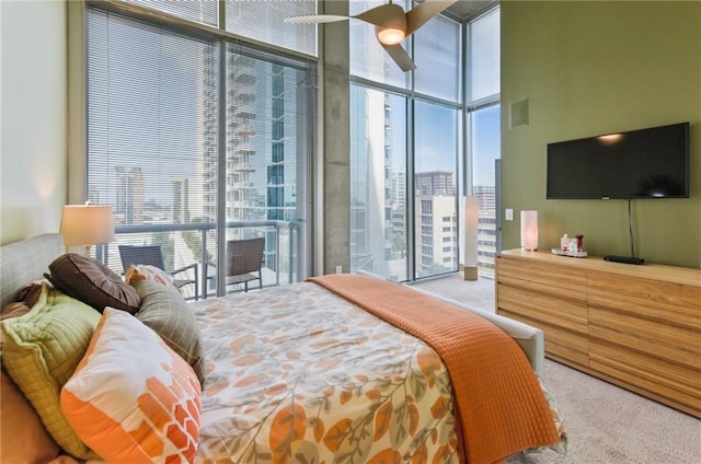 bedroom featuring access to outside, floor to ceiling windows, multiple windows, and light colored carpet