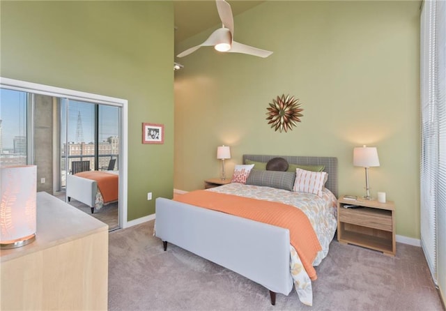 carpeted bedroom with ceiling fan, access to exterior, and a towering ceiling