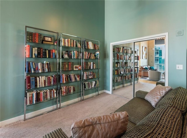 sitting room with light carpet and a towering ceiling