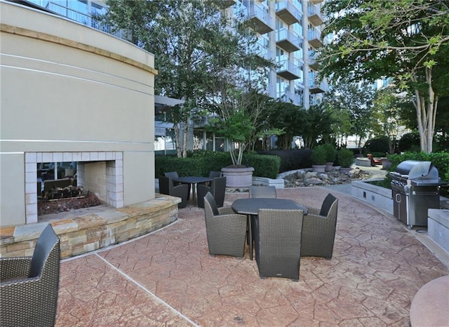 view of terrace featuring grilling area, a tiled fireplace, and area for grilling