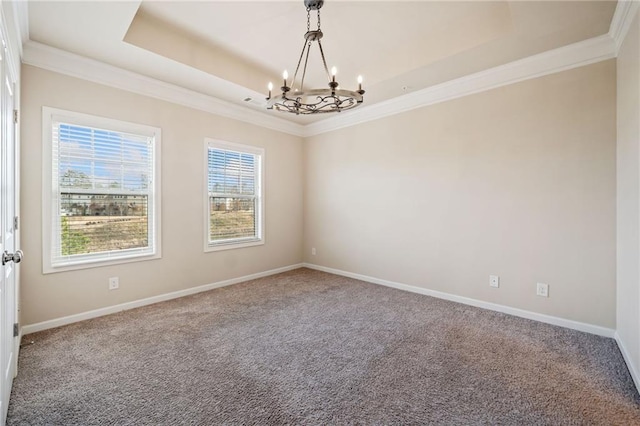 carpeted empty room with a raised ceiling and a chandelier