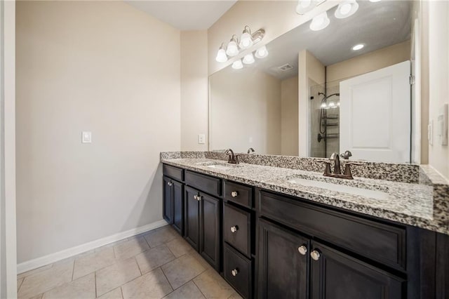 bathroom featuring tile patterned flooring, a tile shower, and vanity