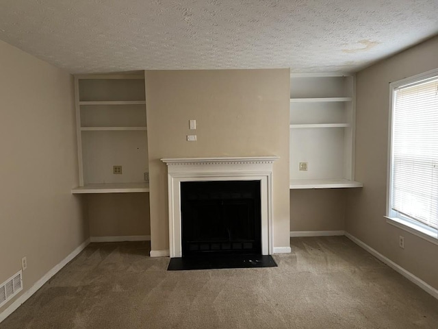 unfurnished living room with a wealth of natural light, a textured ceiling, and carpet flooring