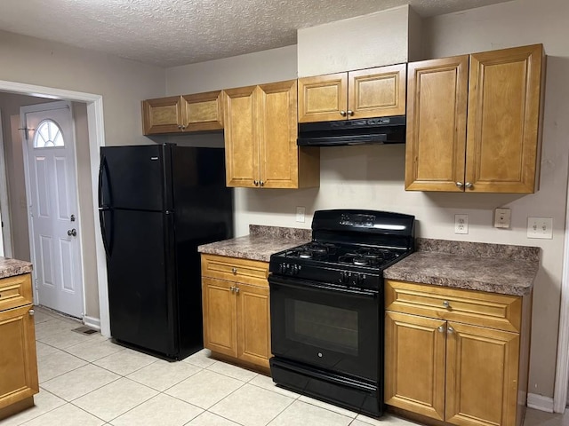 kitchen featuring a textured ceiling, light tile patterned floors, and black appliances