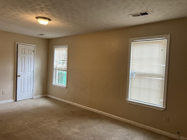 carpeted spare room with a textured ceiling