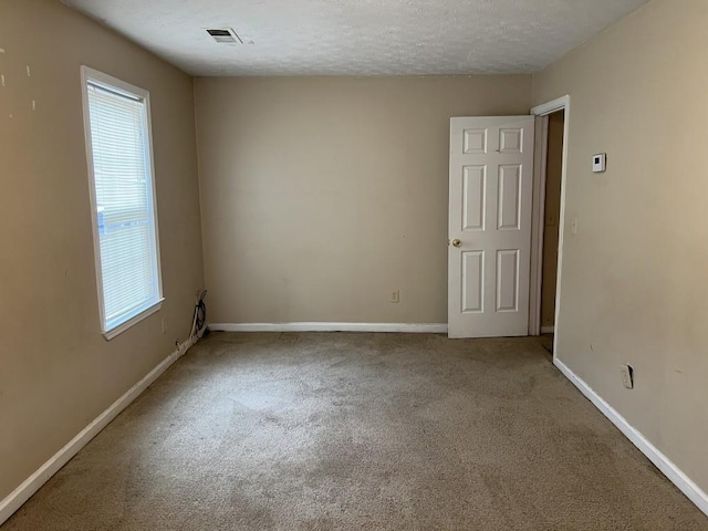 carpeted spare room featuring a textured ceiling