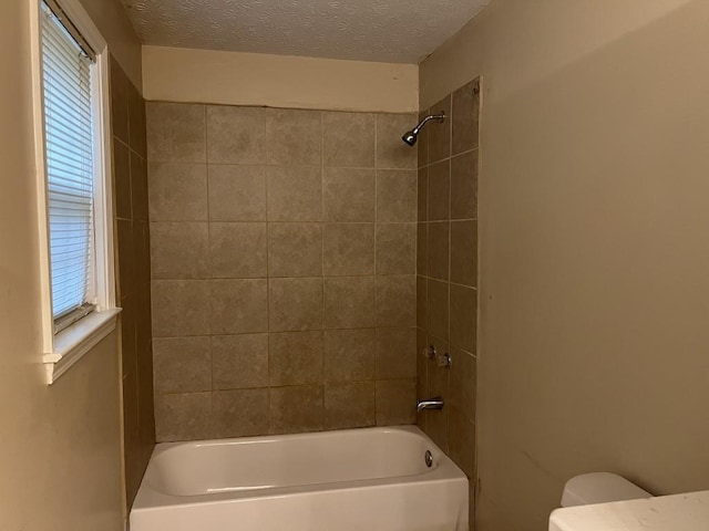 bathroom featuring toilet, a textured ceiling, and plenty of natural light