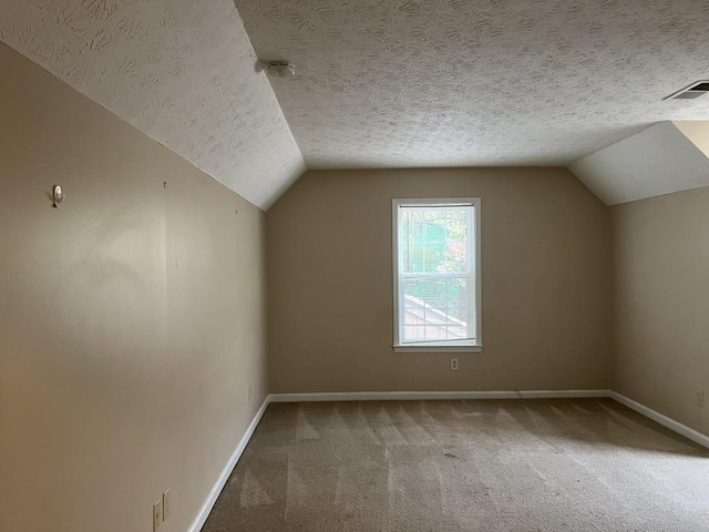 bonus room featuring carpet, a textured ceiling, and vaulted ceiling