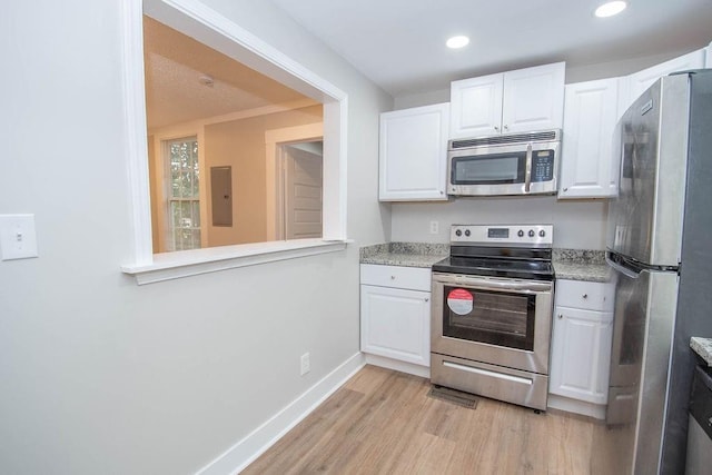 1402 Elm St, Lagrange, GA 30240 - kitchen with electric panel, baseboards, white cabinets, light wood-style floors, and stainless steel appliances