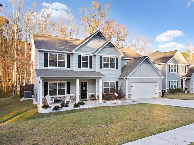 view of front of house featuring a front yard, a porch, central AC, and a garage