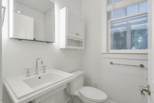 half bathroom featuring toilet and a sink