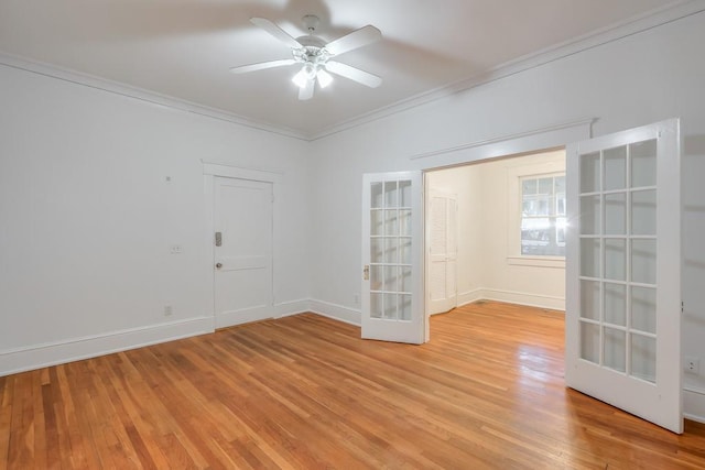 unfurnished room featuring crown molding, light wood-style flooring, ceiling fan, baseboards, and french doors