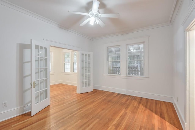 unfurnished room with french doors, crown molding, light wood-style floors, baseboards, and a ceiling fan