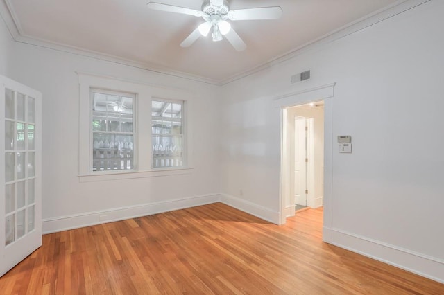 empty room with ornamental molding, light wood-type flooring, baseboards, and a ceiling fan
