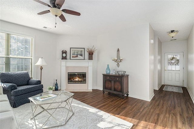 living room featuring ceiling fan, a textured ceiling, and hardwood / wood-style floors