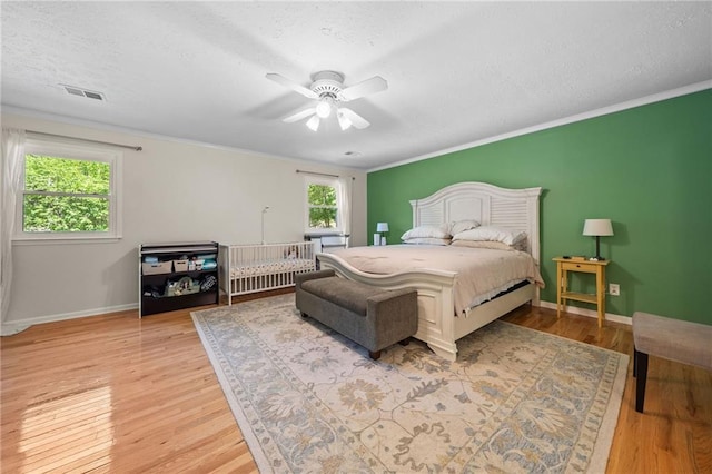 1438 Heritage Glen Dr, Marietta, GA 30068 - bedroom with light wood finished floors, crown molding, ceiling fan, and a textured ceiling