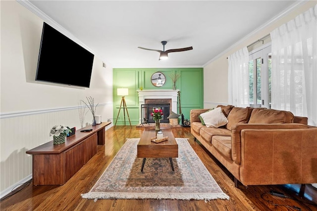 1438 Heritage Glen Dr, Marietta, GA 30068 - living area featuring wood finished floors, a brick fireplace, a ceiling fan, ornamental molding, and a decorative wall