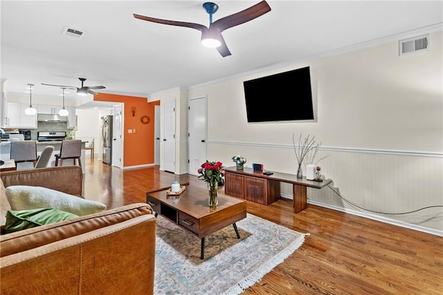 1438 Heritage Glen Dr, Marietta, GA 30068 - living area featuring ceiling fan, light wood-type flooring, crown molding, and wainscoting