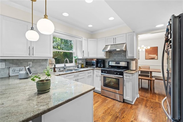 1438 Heritage Glen Dr, Marietta, GA 30068 - kitchen featuring stainless steel appliances, under cabinet range hood, light stone countertops, ornamental molding, and white cabinets