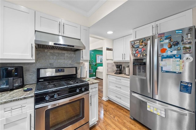 1438 Heritage Glen Dr, Marietta, GA 30068 - kitchen with stainless steel appliances, under cabinet range hood, ornamental molding, white cabinetry, and light wood finished floors