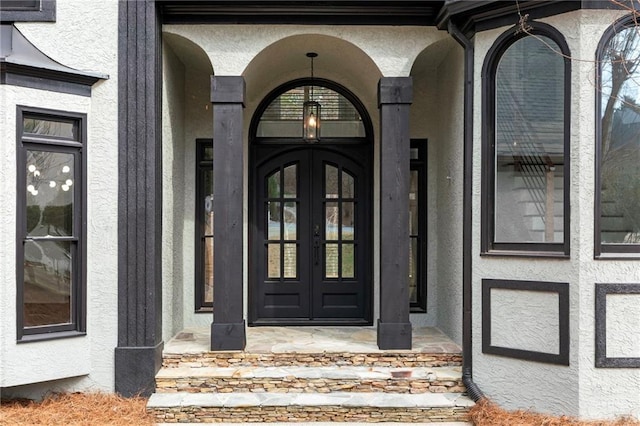 property entrance featuring french doors and stucco siding