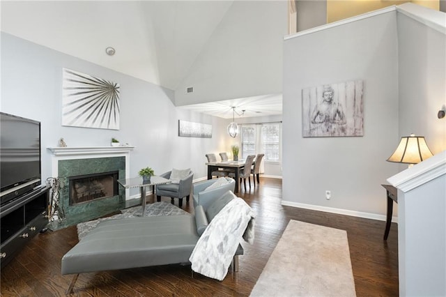 living room with a fireplace, high vaulted ceiling, and dark hardwood / wood-style floors