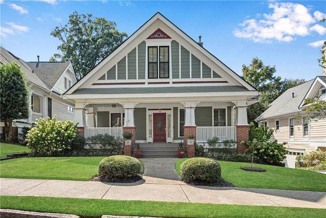 view of front of home with covered porch and a front lawn