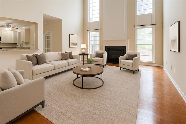 1713 Paramore Pl NE, Marietta, GA 30062 - living room featuring a high ceiling, light wood-style flooring, a fireplace with flush hearth, and a ceiling fan