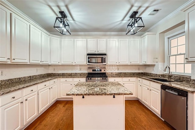 1713 Paramore Pl NE, Marietta, GA 30062 - kitchen featuring stainless steel appliances, a center island, white cabinetry, and crown molding