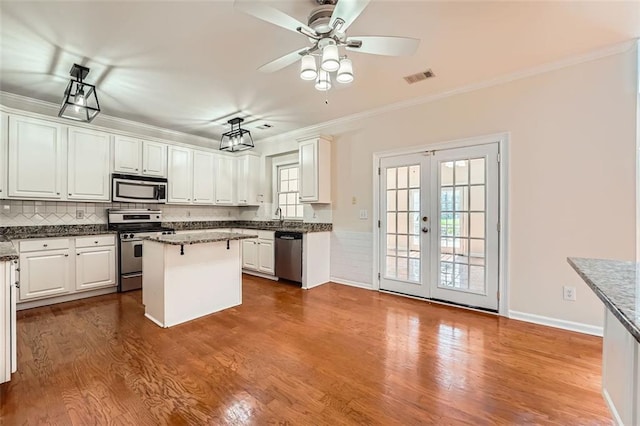 1713 Paramore Pl NE, Marietta, GA 30062 - kitchen with appliances with stainless steel finishes, french doors, ornamental molding, a kitchen island, and white cabinets