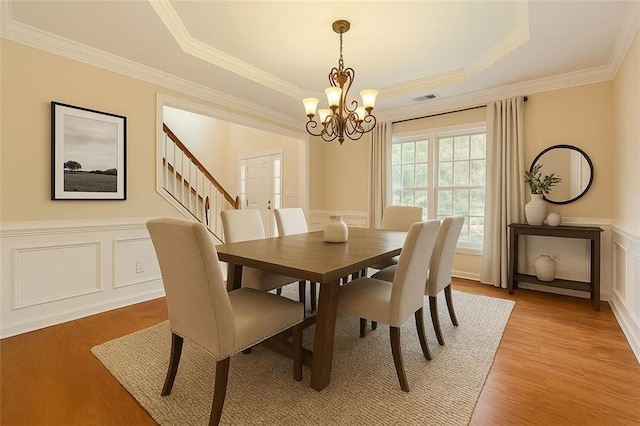 1713 Paramore Pl NE, Marietta, GA 30062 - dining area with a tray ceiling, ornamental molding, a chandelier, light wood-type flooring, and wainscoting